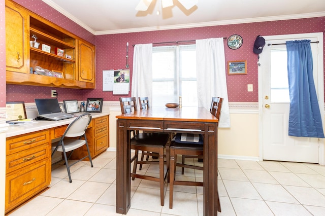 tiled dining space with crown molding, built in desk, and ceiling fan