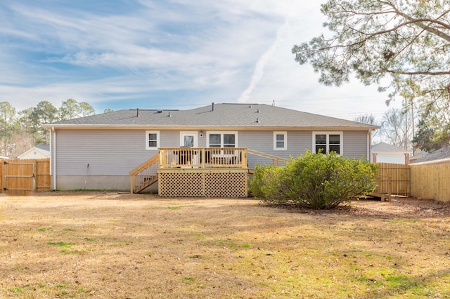 back of house with a wooden deck and a lawn