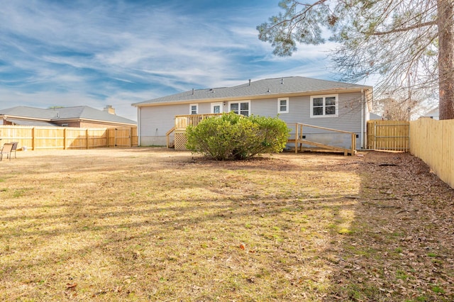 rear view of property featuring a deck and a lawn