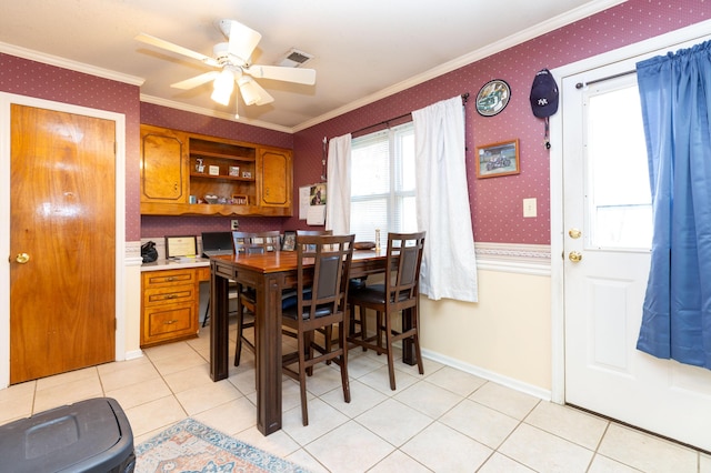 tiled dining room with crown molding and ceiling fan