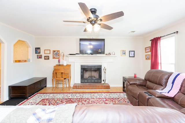 living room featuring hardwood / wood-style flooring, ornamental molding, and ceiling fan