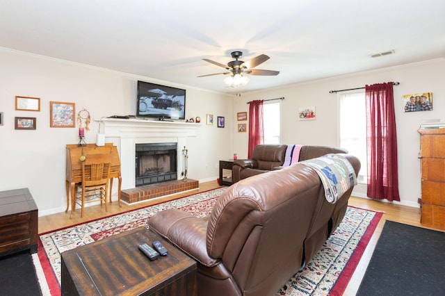 living room with a fireplace, light hardwood / wood-style flooring, and ornamental molding