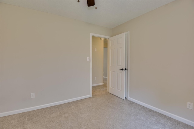unfurnished room featuring carpet floors, a ceiling fan, and baseboards