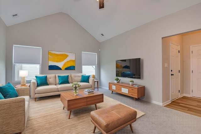 living area with high vaulted ceiling, baseboards, light carpet, and visible vents