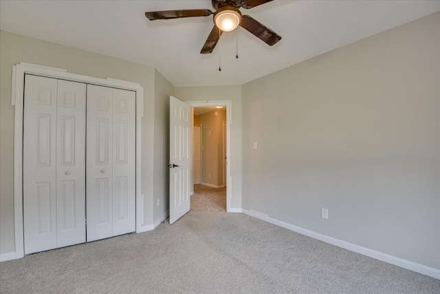 unfurnished bedroom featuring baseboards, a closet, and light colored carpet