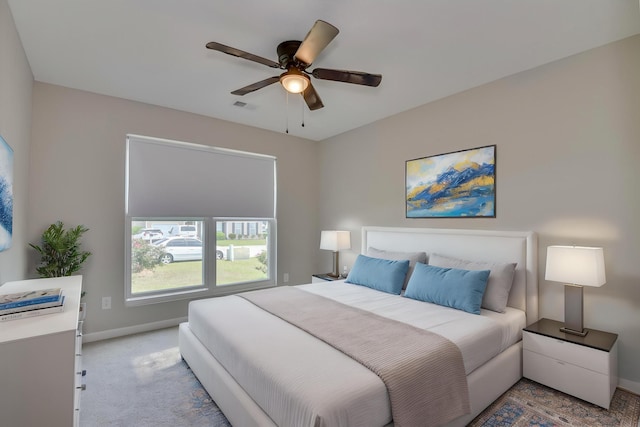 bedroom featuring baseboards, ceiling fan, light carpet, and visible vents