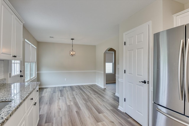 610 Creek Bottom Trl, Grovetown, GA 30813 - kitchen featuring freestanding refrigerator, arched walkways, white cabinetry, and light wood-type flooring