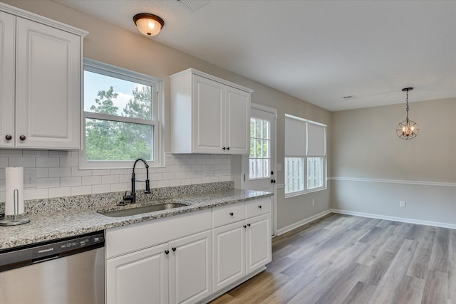 kitchen with stainless steel dishwasher, white cabinetry, a sink, and tasteful backsplash