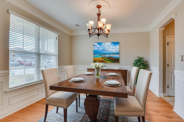 7050 Summerton Dr, Augusta, GA 30909 - dining room featuring a wainscoted wall, a notable chandelier, ornamental molding, light wood-style floors, and a decorative wall
