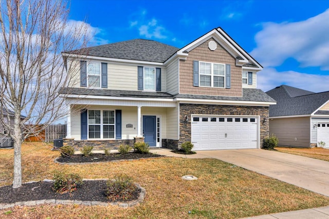 view of front of house featuring fence, covered porch, a garage, stone siding, and driveway