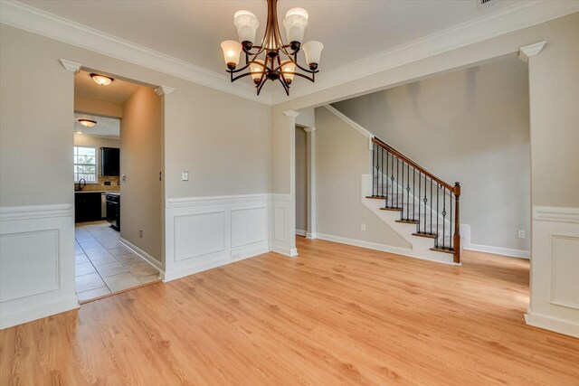 spare room featuring stairs, ornamental molding, wainscoting, and wood finished floors