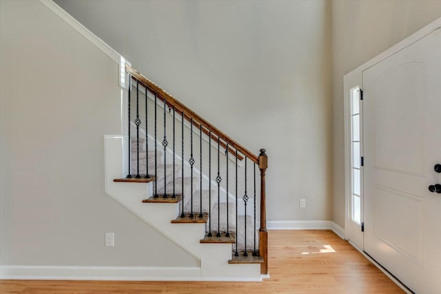 entryway featuring stairway, light wood-style flooring, and baseboards