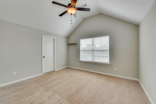 unfurnished room with lofted ceiling, light colored carpet, visible vents, a ceiling fan, and baseboards