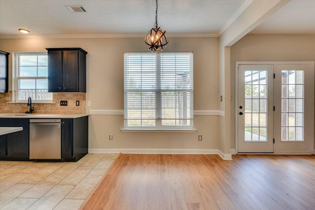 kitchen featuring light countertops, hanging light fixtures, backsplash, visible vents, and stainless steel dishwasher