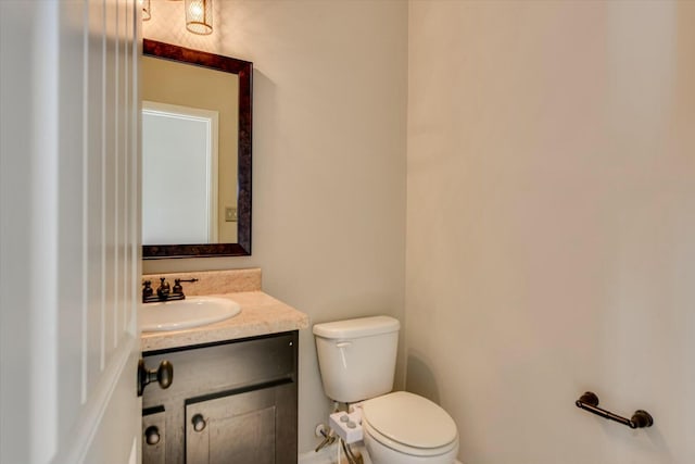 half bathroom with vanity and toilet