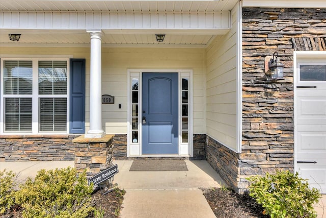 entrance to property with stone siding and covered porch