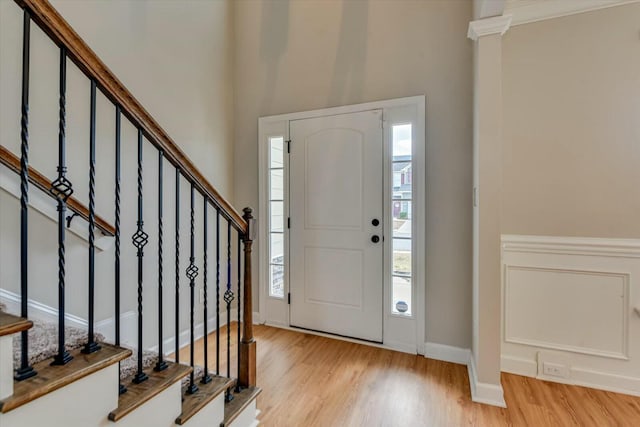 entrance foyer with light wood-style floors, stairs, and baseboards