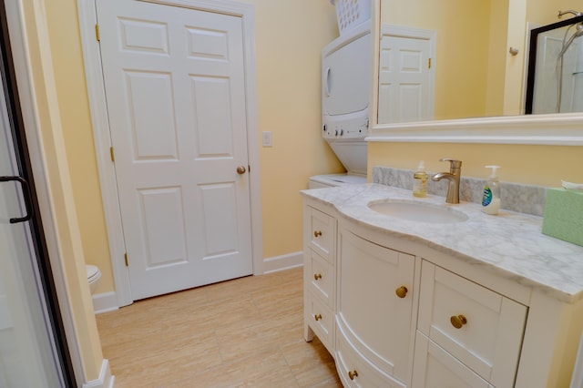 148 Grandview Dr, Mccormick, SC 29835 - bathroom featuring baseboards, stacked washer and dryer, toilet, and vanity