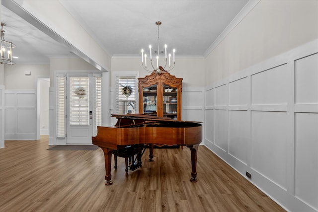 sitting room featuring crown molding, a decorative wall, and a notable chandelier