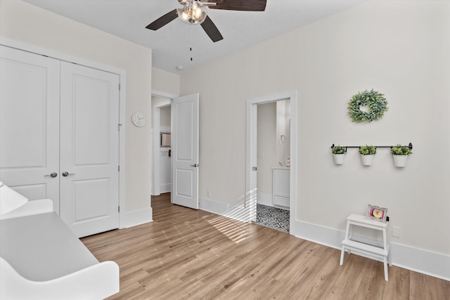 bedroom with light wood-type flooring, baseboards, a closet, and connected bathroom