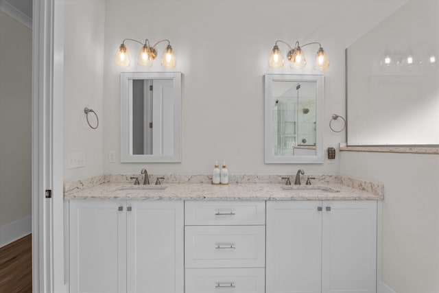 bathroom with double vanity, a shower, and a sink