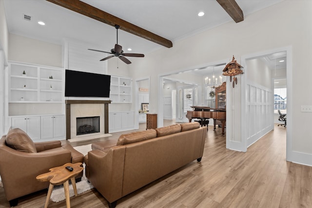 living room with visible vents, baseboards, beamed ceiling, attic access, and light wood-style floors