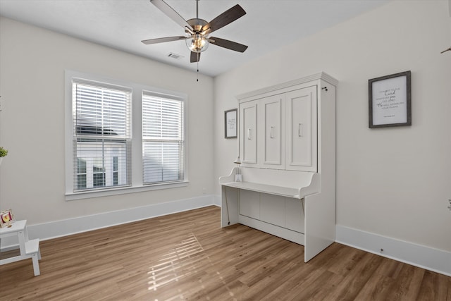 interior space featuring visible vents, a ceiling fan, baseboards, and light wood finished floors