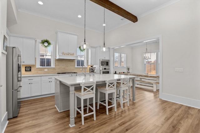 kitchen with decorative backsplash, white cabinetry, appliances with stainless steel finishes, and light countertops