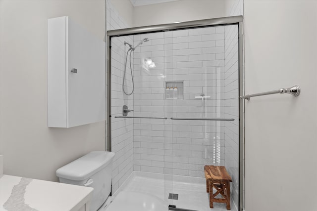 bathroom featuring toilet and a stall shower