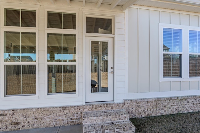 entrance to property with brick siding and board and batten siding