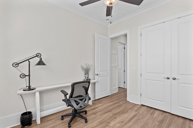 office space featuring light wood-type flooring, baseboards, a ceiling fan, and crown molding