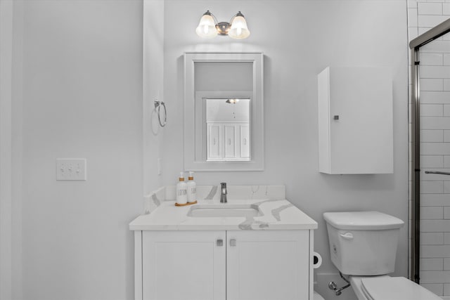 bathroom featuring vanity, toilet, and a tile shower