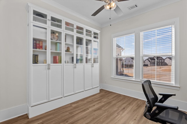 home office with visible vents, light wood-style flooring, crown molding, and ceiling fan