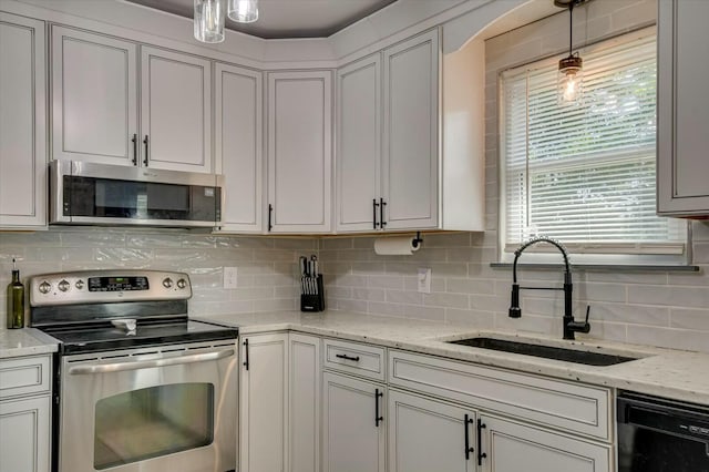 kitchen with white cabinetry, sink, decorative backsplash, hanging light fixtures, and stainless steel appliances