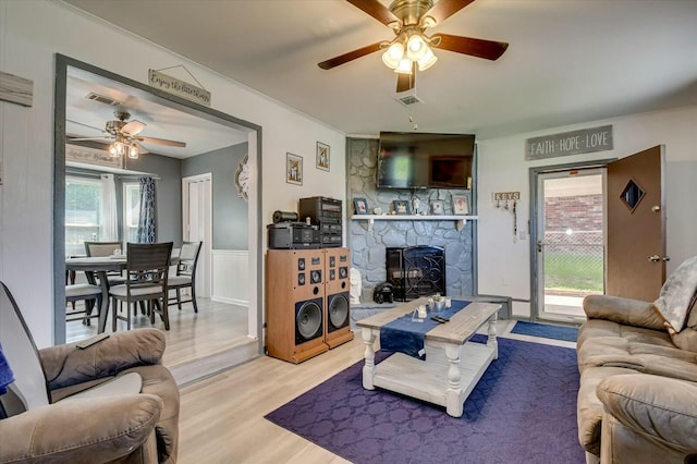 living room with crown molding, ceiling fan, and light wood-type flooring