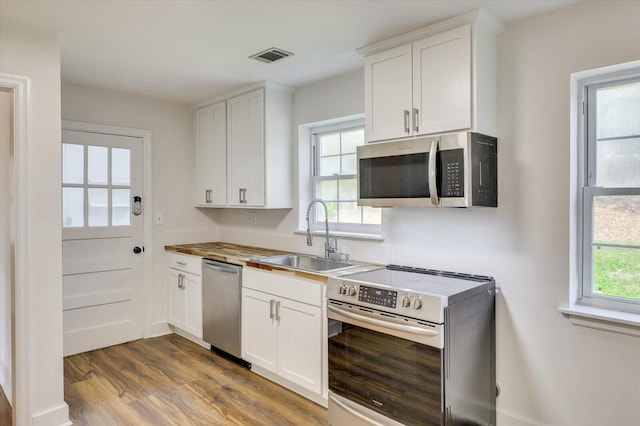 kitchen with white cabinets, stainless steel appliances, dark wood-type flooring, and sink