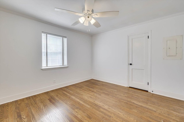 empty room with light wood-type flooring, electric panel, and ornamental molding