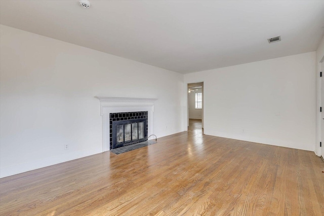 unfurnished living room with a fireplace and light hardwood / wood-style flooring