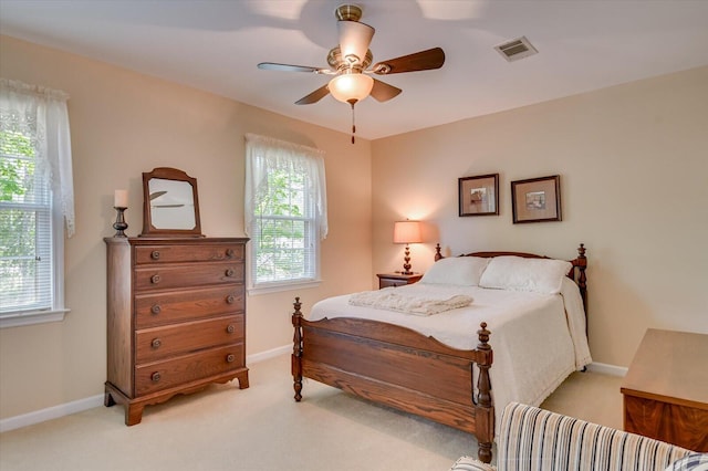 bedroom with baseboards, visible vents, light colored carpet, and ceiling fan