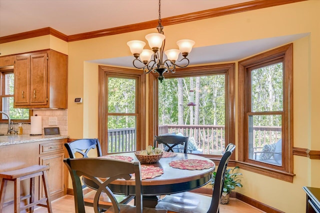 dining space with ornamental molding, a wealth of natural light, and a notable chandelier
