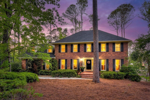 colonial home featuring brick siding