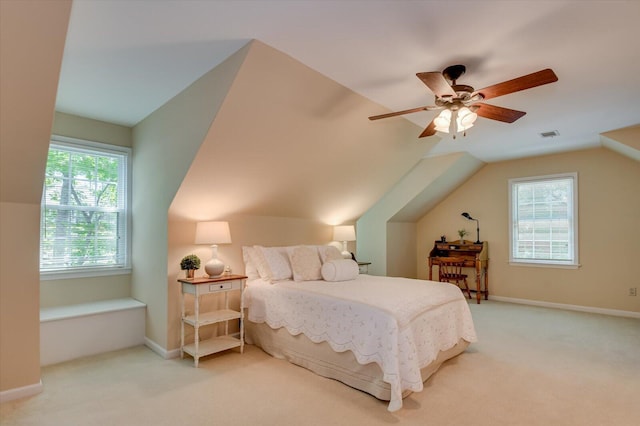 carpeted bedroom featuring baseboards, vaulted ceiling, visible vents, and a ceiling fan