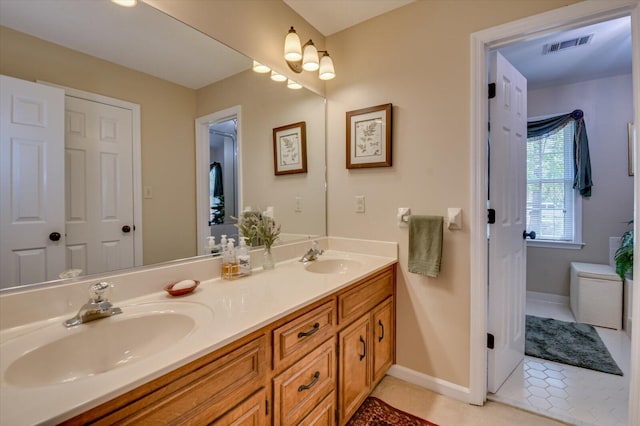 bathroom featuring tile patterned floors, visible vents, a sink, and double vanity