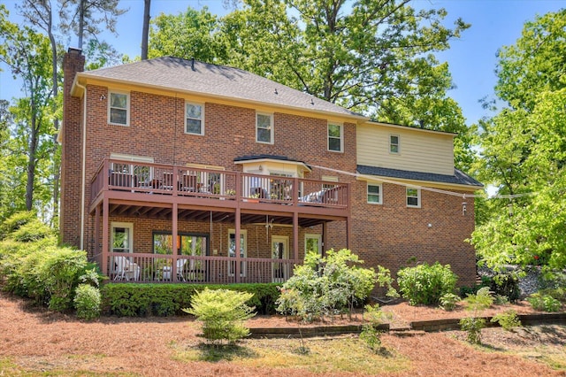 back of house featuring a wooden deck, brick siding, and a chimney