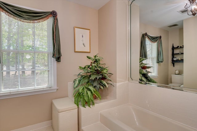 full bathroom featuring baseboards, visible vents, toilet, and a garden tub