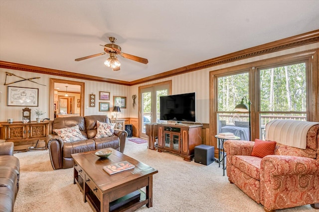 living room featuring a ceiling fan, crown molding, and carpet