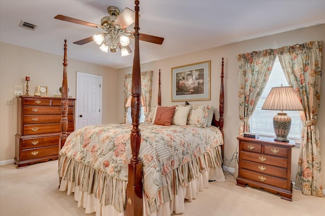 bedroom with ceiling fan, visible vents, baseboards, and light carpet