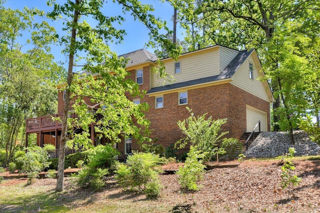back of house featuring brick siding and a deck