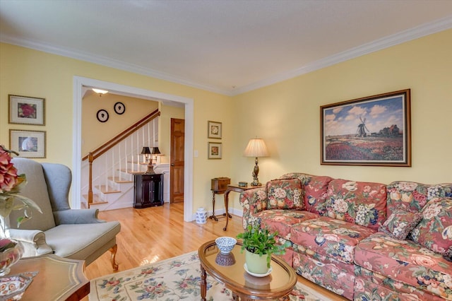 living area featuring wood finished floors, stairs, and ornamental molding