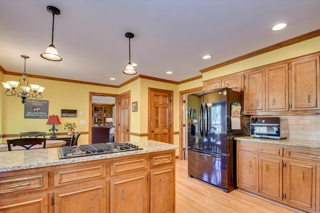 kitchen with recessed lighting, light wood-style floors, stainless steel gas stovetop, black fridge with ice dispenser, and pendant lighting